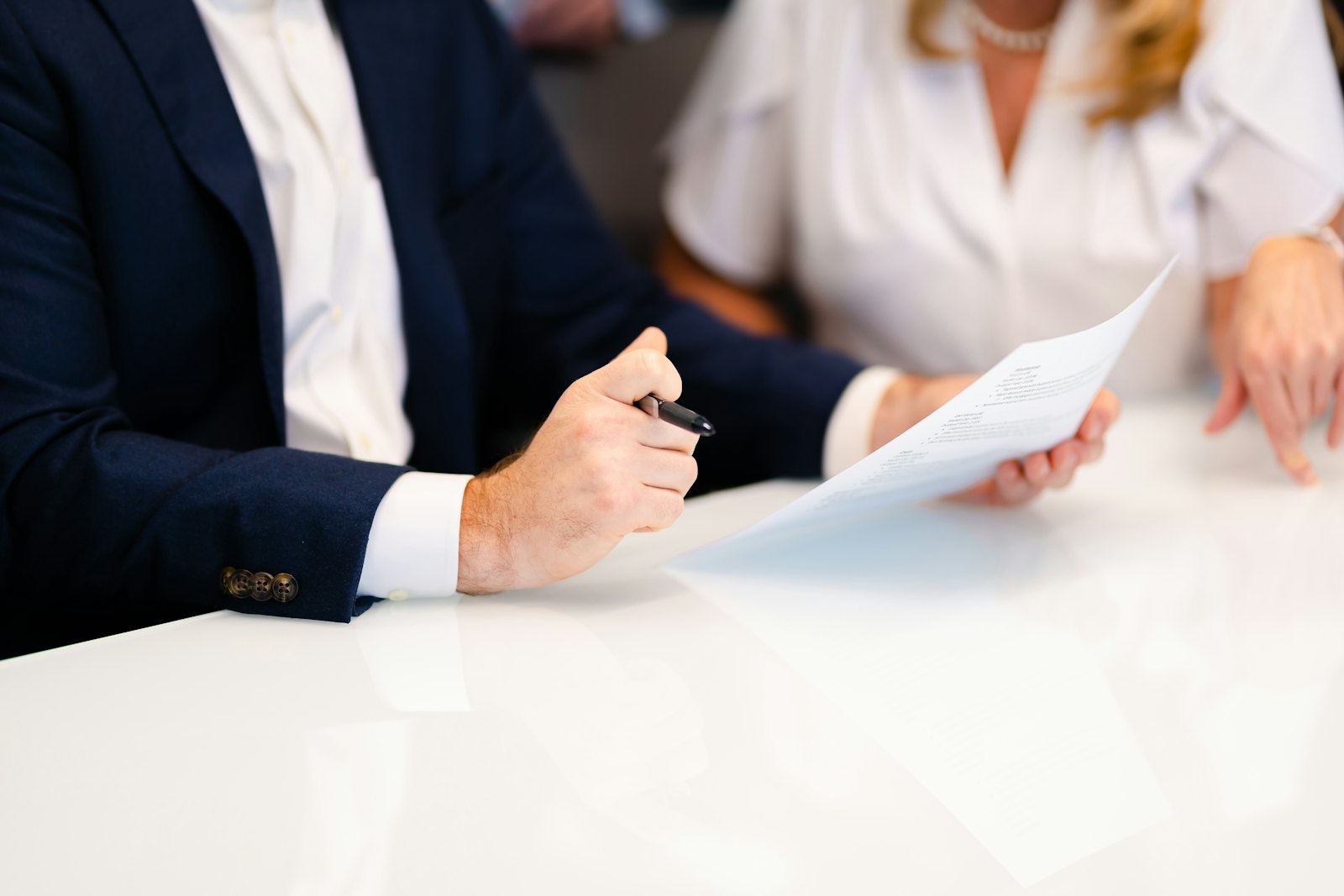 Counsel reviewing a printed agreement across a conference table