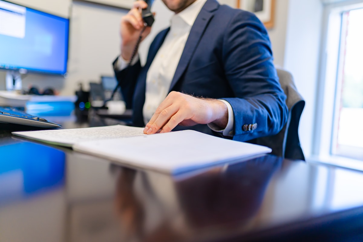 A completion specialist on a desk phone, working through an agreement file